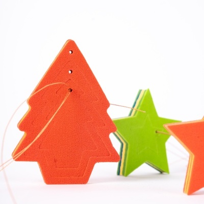 Ornamentos de tecido em forma de árvore e estrela em cores laranja e verde sobre fundo branco