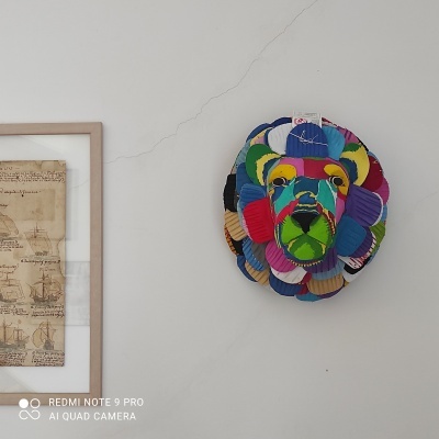 Máscara de parede colorida em tecido representando cabeça de leão