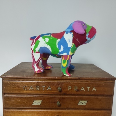 Figura decorativa de cão colorido sobre móvel de madeira com texto 'CARTA PRATA'