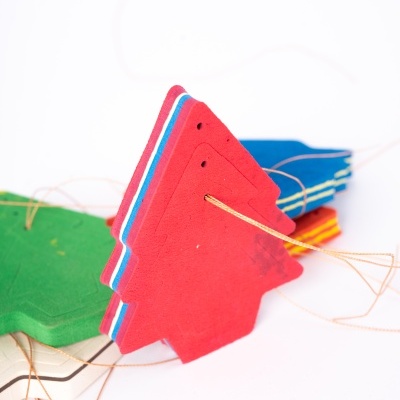 Cartões coloridos em forma de árvore de natal com fios finos num fundo branco