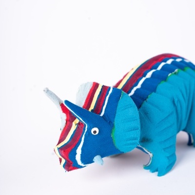 Pelúcia dinossauro Triceratops colorido com padrões listrados