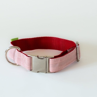 Coleira vermelha e rosa de tecido com fecho e argola metálica sobre fundo branco