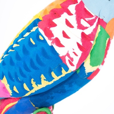 Brinquedo ou decoração de tecido em forma de pássaro colorido com detalhes costurados e pintados