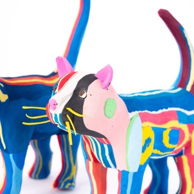 Esculturas de gatos coloridos em tecido com padrões listrados e manchas