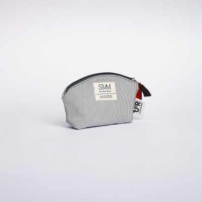 Bolsa pequena cinzenta de tecido com etiquetas e fecho