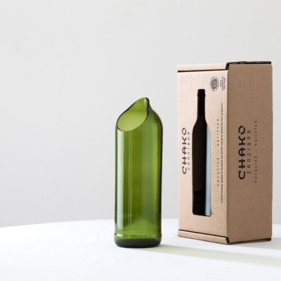 Garrafa verde reciclada com caixa de cartão castanho ao lado