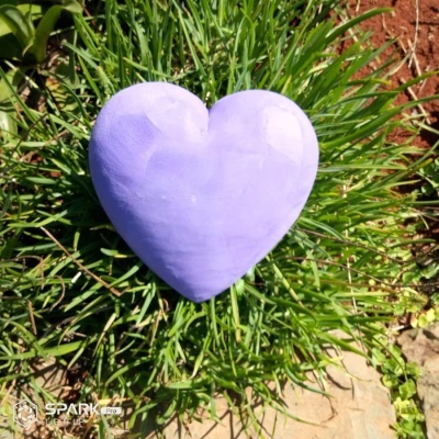 Objeto coração lavanda sobre plantas verdes