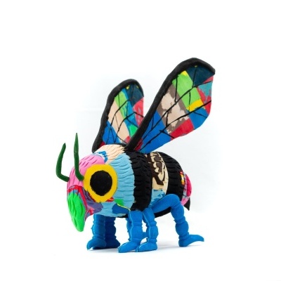 Inseto de pelúcia colorido com asas em padrão vitral