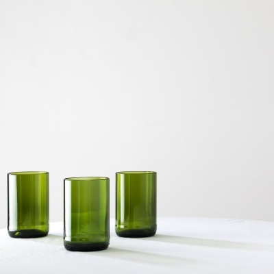 Três copos verdes de vidro sobre superfície branca