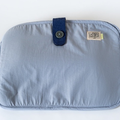 Estojo azul claro com fecho azul escuro e etiqueta LUCAS MAKES MAGIC