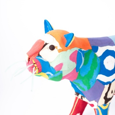 Estátua colorida de gato em tecido com múltiplas cores e padrões