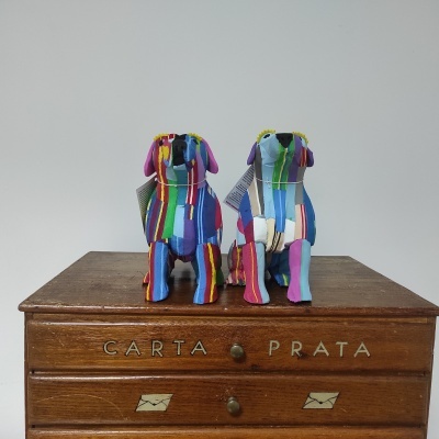 Estatuetas de cães coloridas em tecido sobre caixa de madeira 'CARTA PRATA'