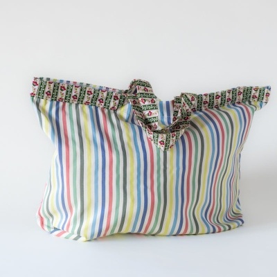 Bolsa de tecido colorida com riscas verticais e borda floral