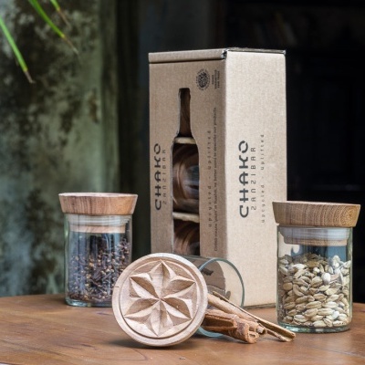 Frascos de especiarias com tampas de madeira, embalagem CHAKKO e moedor de madeira sobre mesa