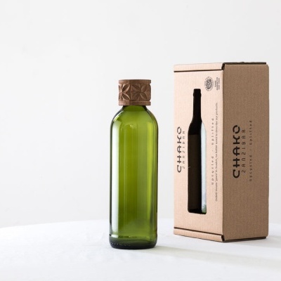 Garrafa verde de vidro com embalagem de cartão castanho
