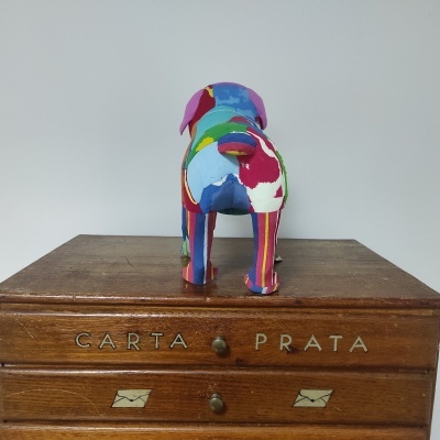 Escultura de cão colorida em cima de caixa de madeira com texto CARTA PRATA