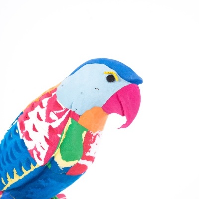 Boneco de peluche papagaio colorido em suporte rosa