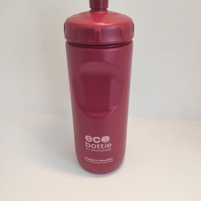 Garrafa vermelha ecológica com tampa e texto branco 'eco bottle by smartshake'.