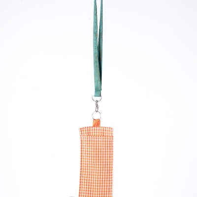 Capa laranja xadrez para óculos pendurada num cordão verde