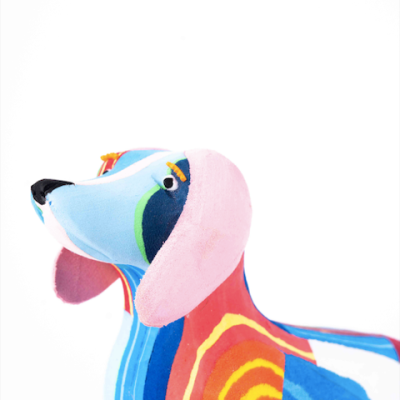 Boneco de cão colorido em tecido com padrões listrados