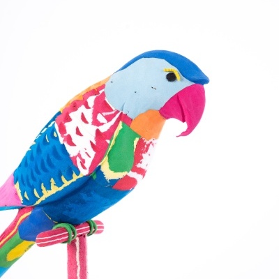 Pássaro de tecido colorido em suporte de tecido rosa