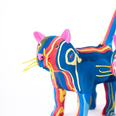 Escultura colorida de gato em tecido com fundo branco