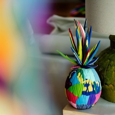 Fruteira decorativa colorida em forma de ananás com padrões geométricos e textura em tecido