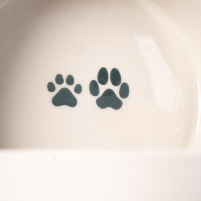 Taça de cerâmica branca com pegadas pretas no interior