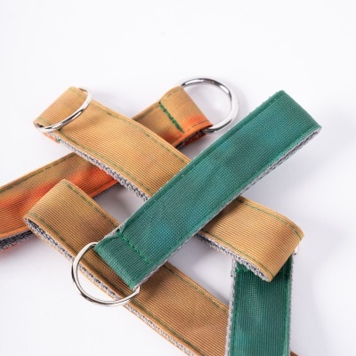 Tiras de tecido verde e castanho com argolas metálicas prateadas