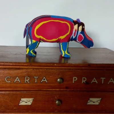 Elefante de pano colorido sobre móvel de madeira com gavetas rotuladas