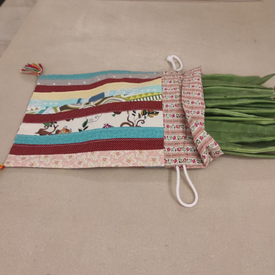 Saco de tecido colorido com feijões verdes frescos