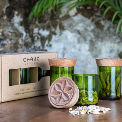 Conjunto de frascos verdes com tampas em cortiça e embalagem CHAKO EM MADEIRA numa mesa de madeira