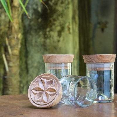 Frascos de vidro com tampas de madeira gravada em mesa de madeira
