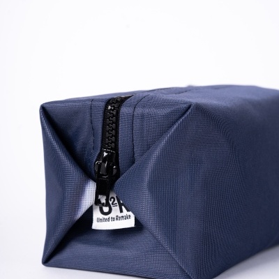 Bolsa de tecido azul escuro com fecho preto e etiqueta branca