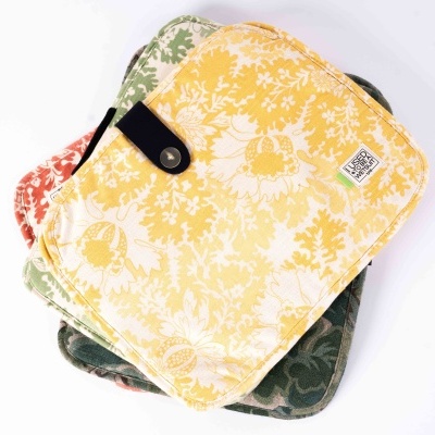 Três carteiras pequenas em tecido floral coloridas empilhadas