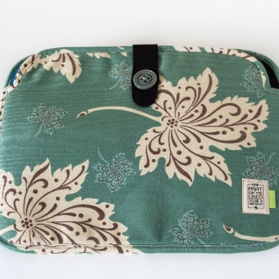 Estojo retangular verde com padrão floral bege e fecho de botão preto