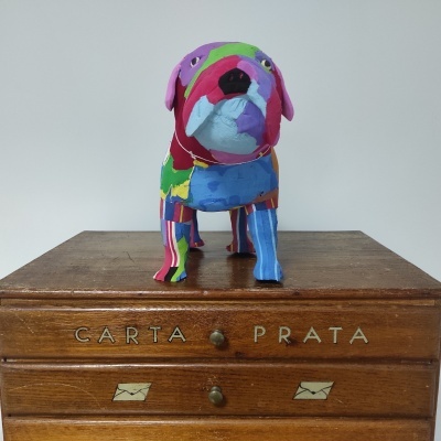 Figura decorativa de cão colorido sobre caixa de madeira com letras CARTA PRATA