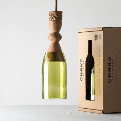 Candeeiro suspenso em vidro verde e madeira ao lado de embalagem de cartão reciclado