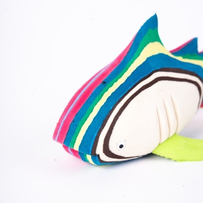 Peluche de peixe colorido com riscas sobre fundo branco