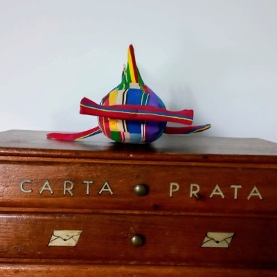 Cômoda de madeira com chapéu colorido em cima