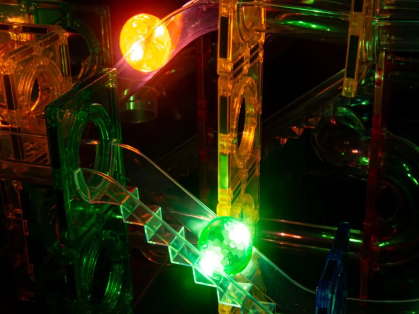 Jogo de percurso de esferas translúcido colorido com luzes verdes e amarelas