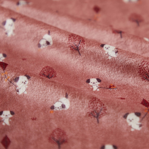 Tecido rosa com padrão de cães e árvores pequenas.