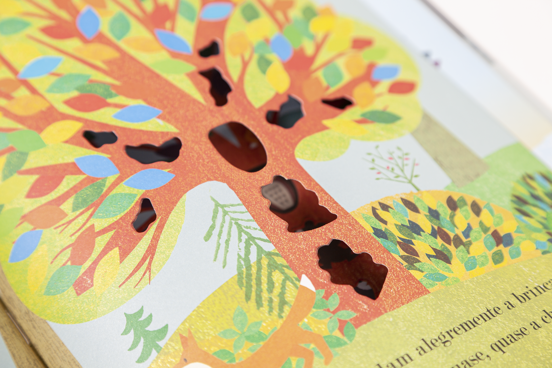 Página de livro infantil com ilustração colorida de árvore com recortes e texto em português