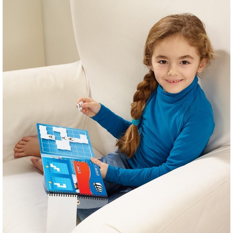 Menina num sofá branco a jogar um jogo de tabuleiro azul com peças brancas e pretas.