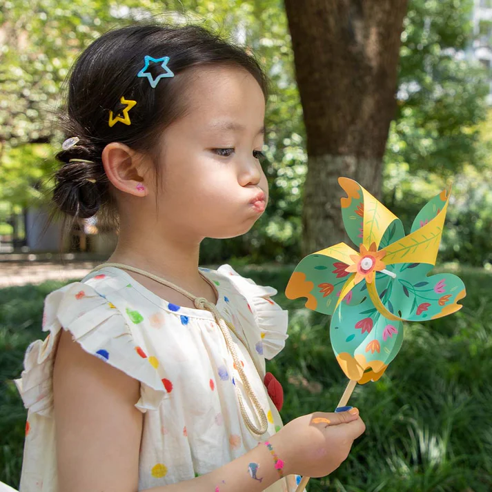 Criança segurar brinquedo catavento colorido em ambiente exterior