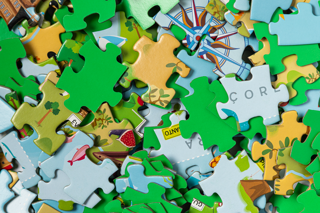Peças de puzzle coloridas espalhadas com desenhos e texto parcial