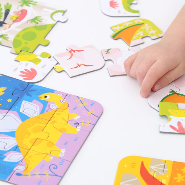 Puzzle colorido com dinossauros e mão de criança a segurar peça