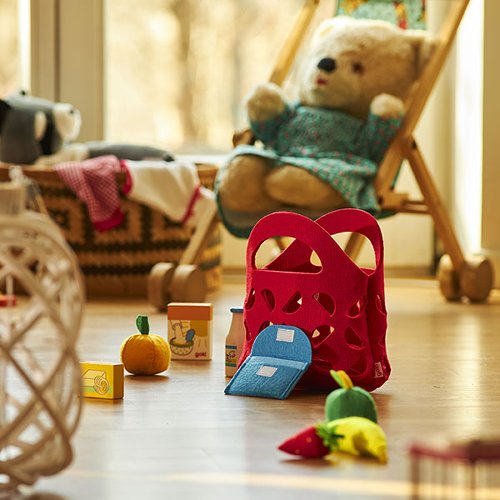 Brinquedos infantis e urso de peluche em ambiente interior com chão de madeira