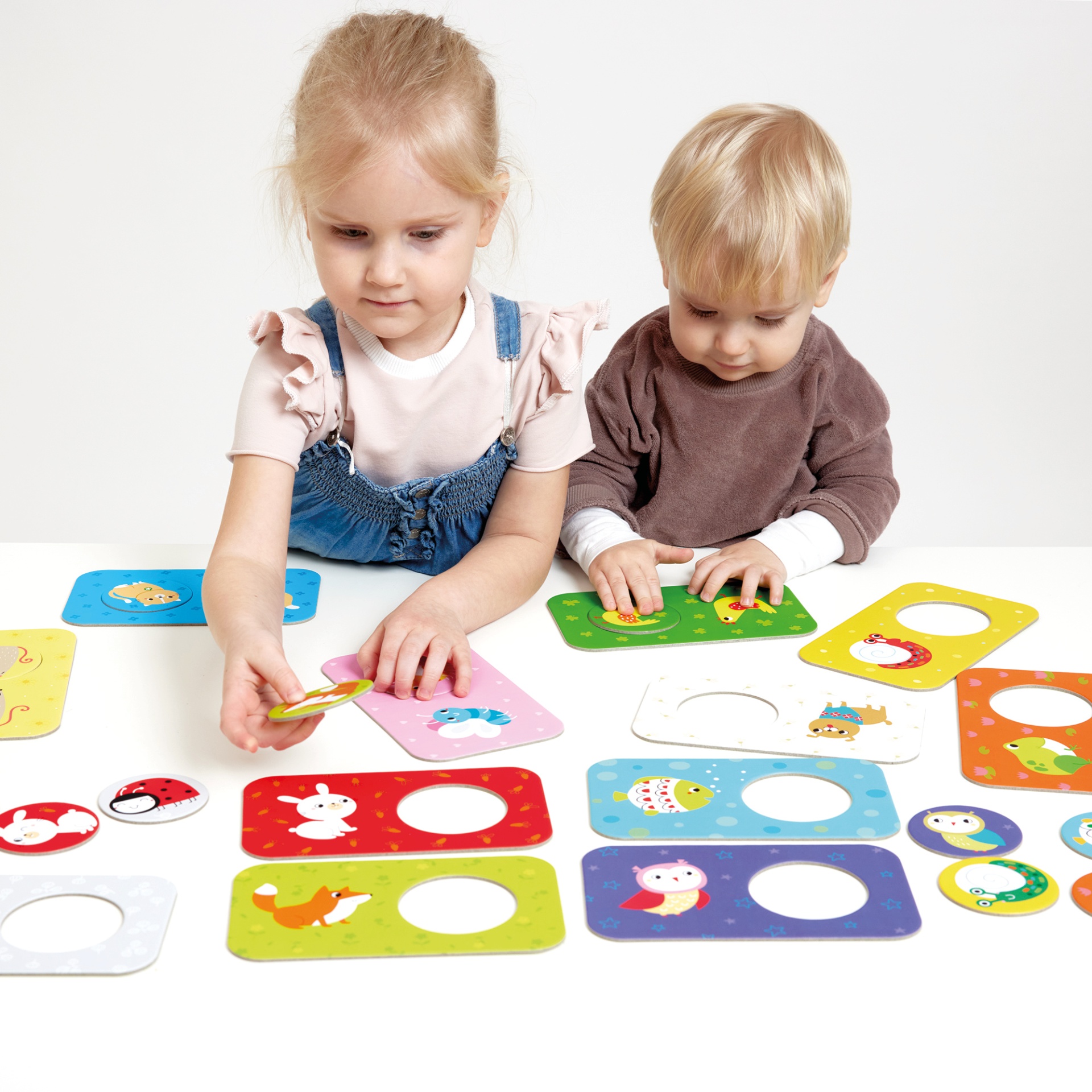 Crianças a jogar com cartas coloridas de animais em fundo branco