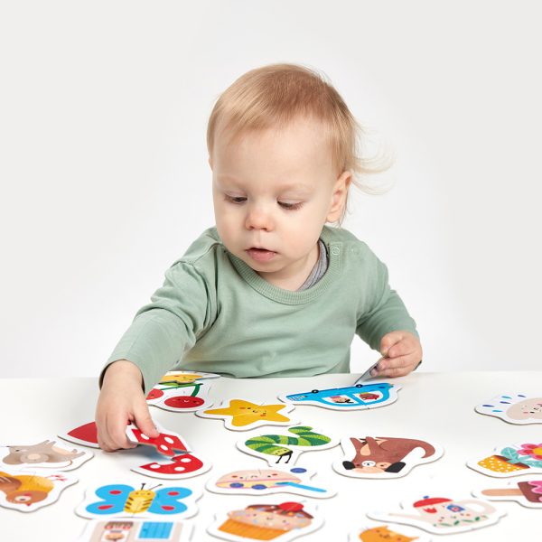 Criança a brincar com puzzle colorido de animais e objetos